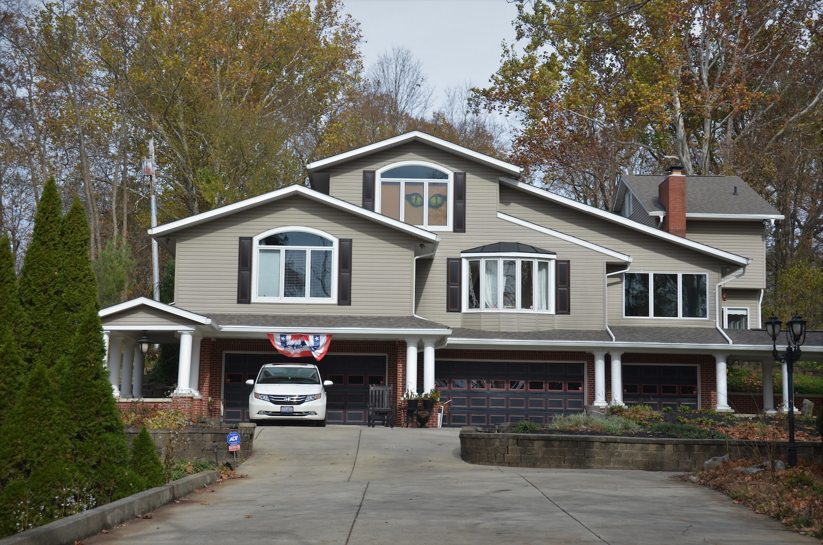 white and gray wooden house near green trees during daytime