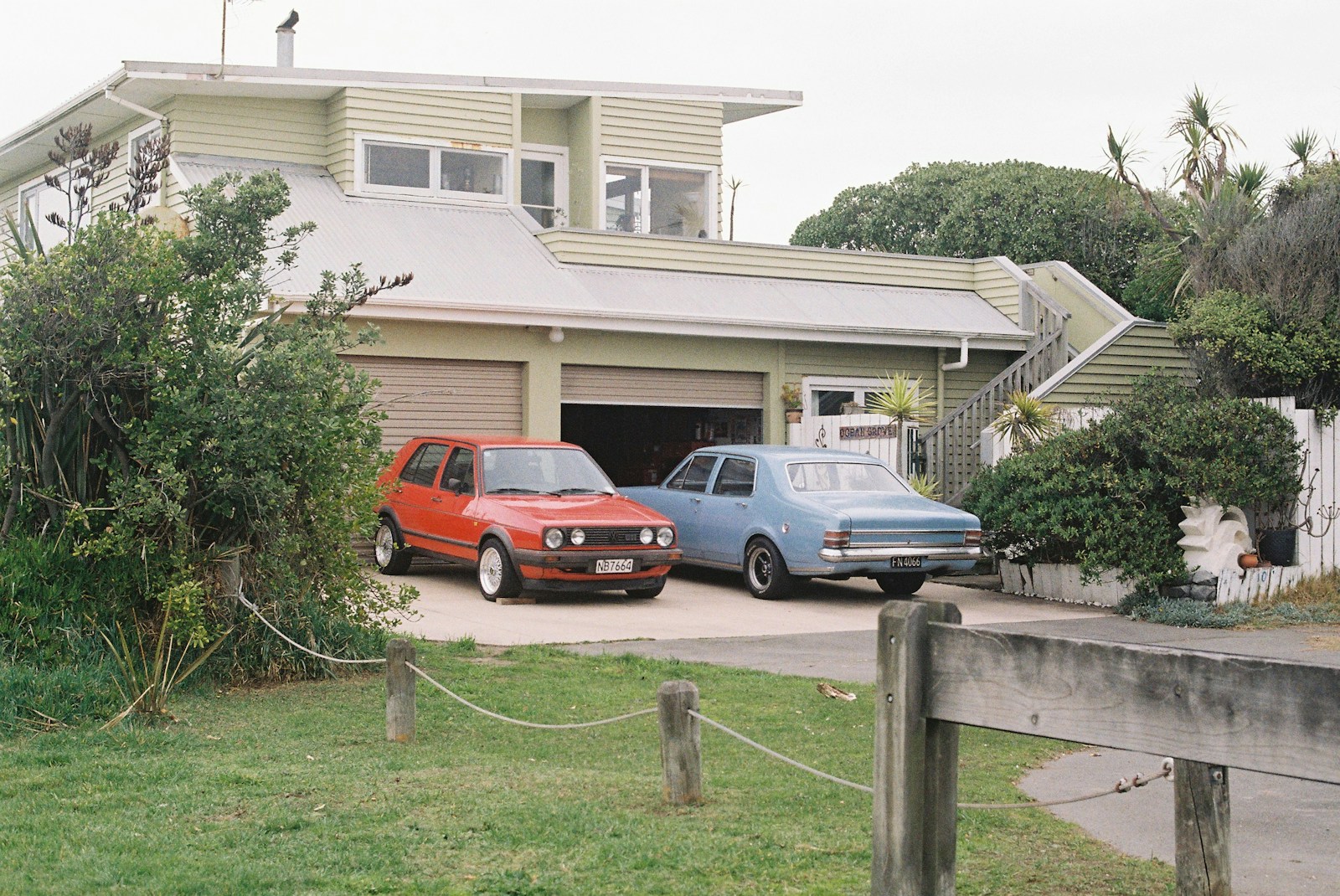 Two cars parked in front of a house